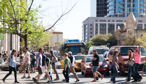 A group of pedestrians crossing a street in downtown Austin